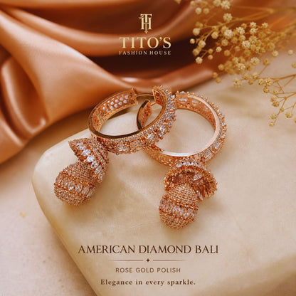 Rose gold earrings on a marble surface with TITO'S Fashion House branding.