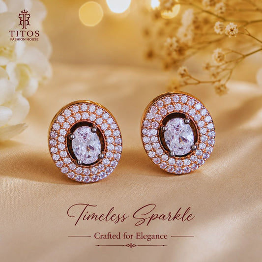 Pair of earrings with diamonds on a beige fabric background, featuring the TITOS Fashion House brand.