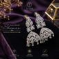 Ornate diamond earrings on a dark fabric background with TITOS Fashion House branding.