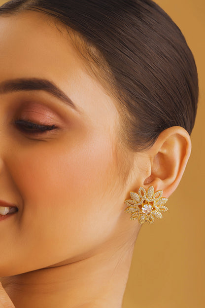 Close-up of a woman wearing a gold earring with a yellow background