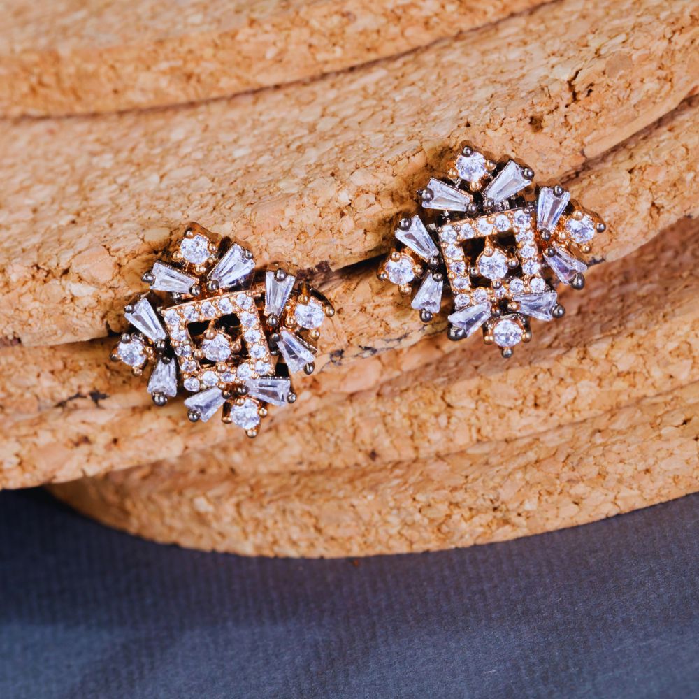 Pair of diamond earrings on a textured wooden surface