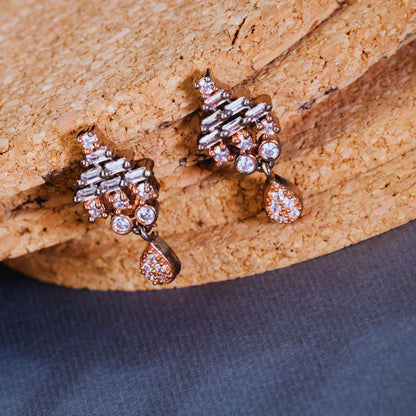Pair of diamond earrings on a textured stone surface