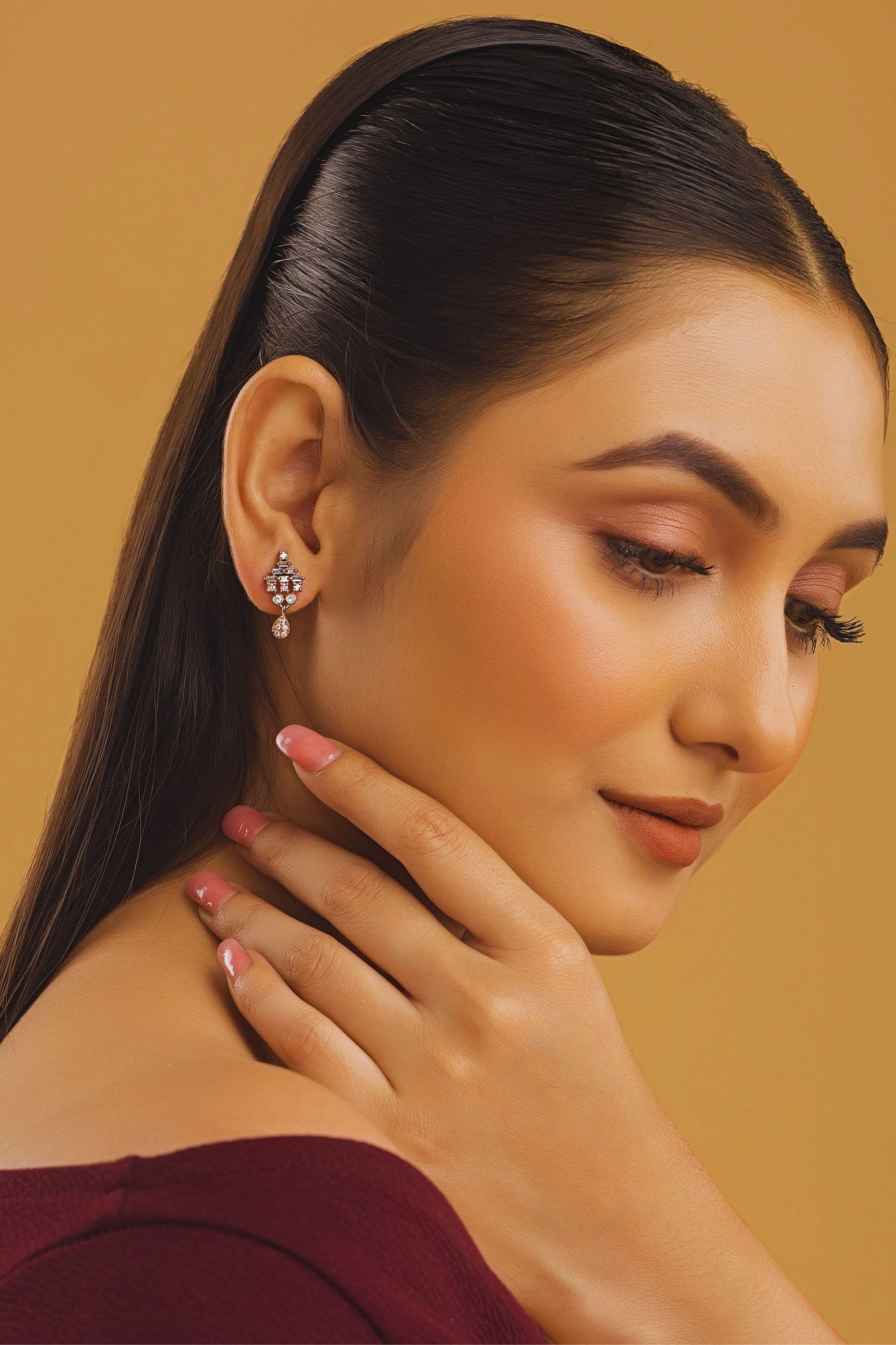 Woman wearing earrings with a neutral background