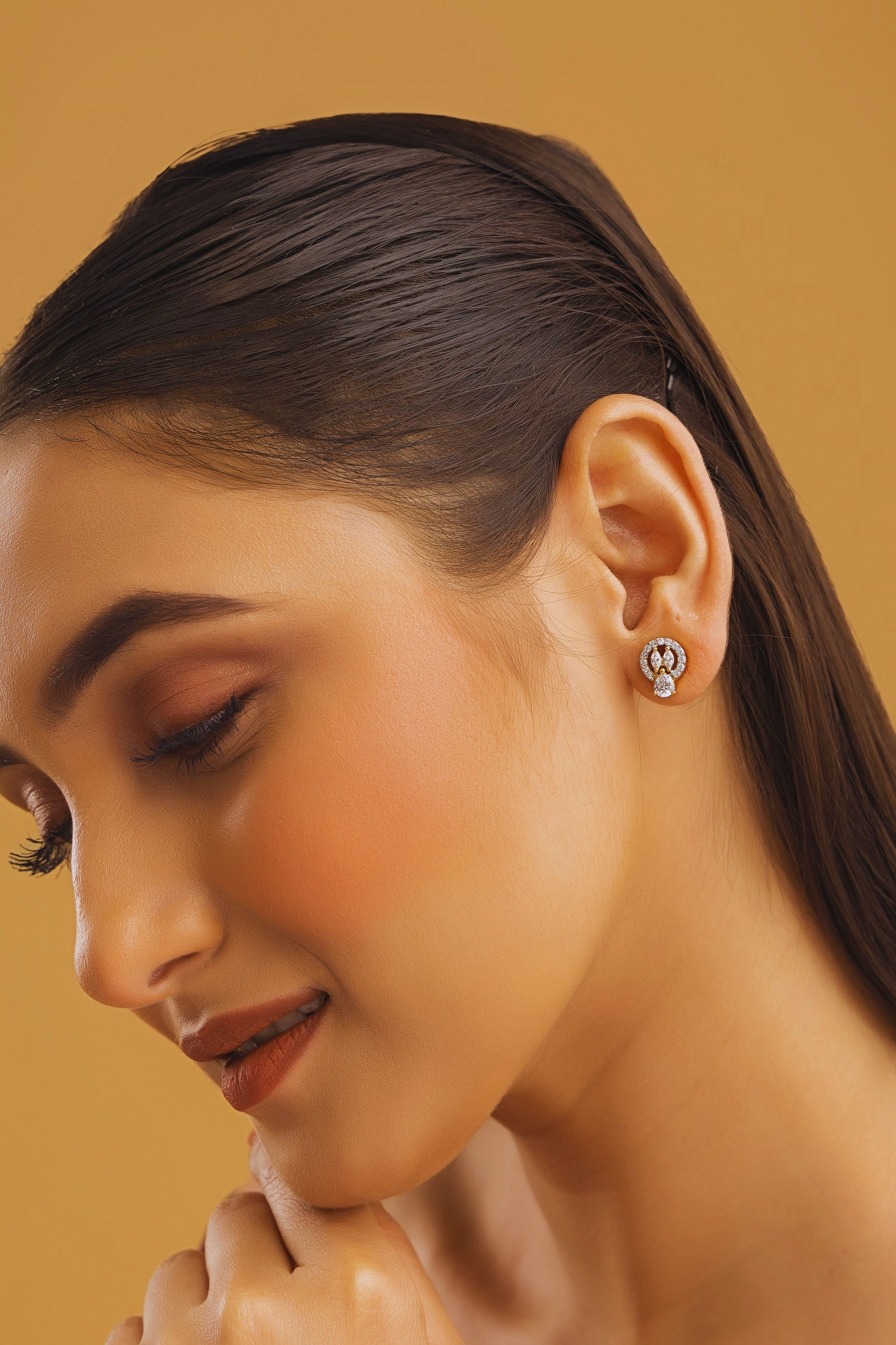 Close-up of a woman wearing earrings with a beige background
