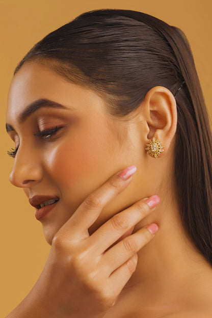 Woman wearing a gold earring on a beige background