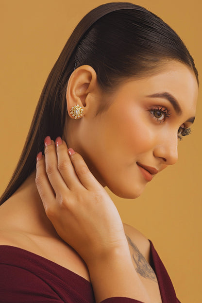 Woman wearing a gold earring on a beige background