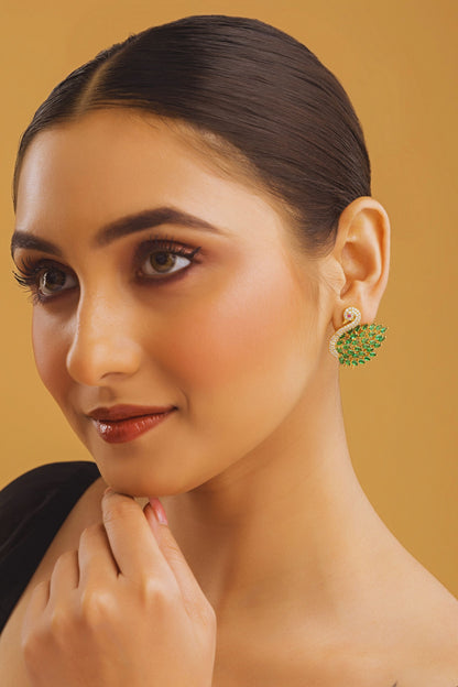 Woman wearing green earrings against a beige background