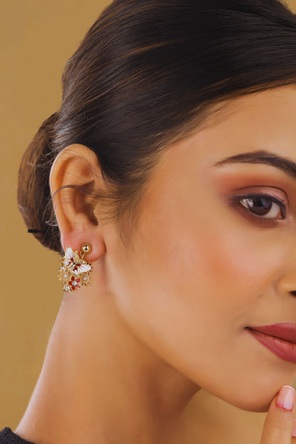 Close-up of a woman wearing a floral earring against a beige background