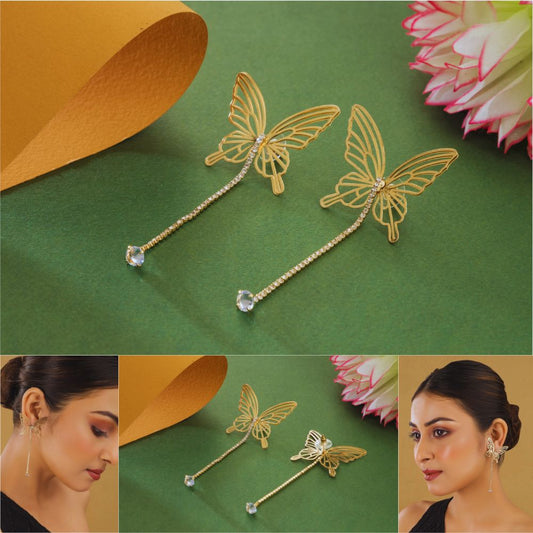 Gold butterfly hairpins with crystal details on a green background, shown on a model.