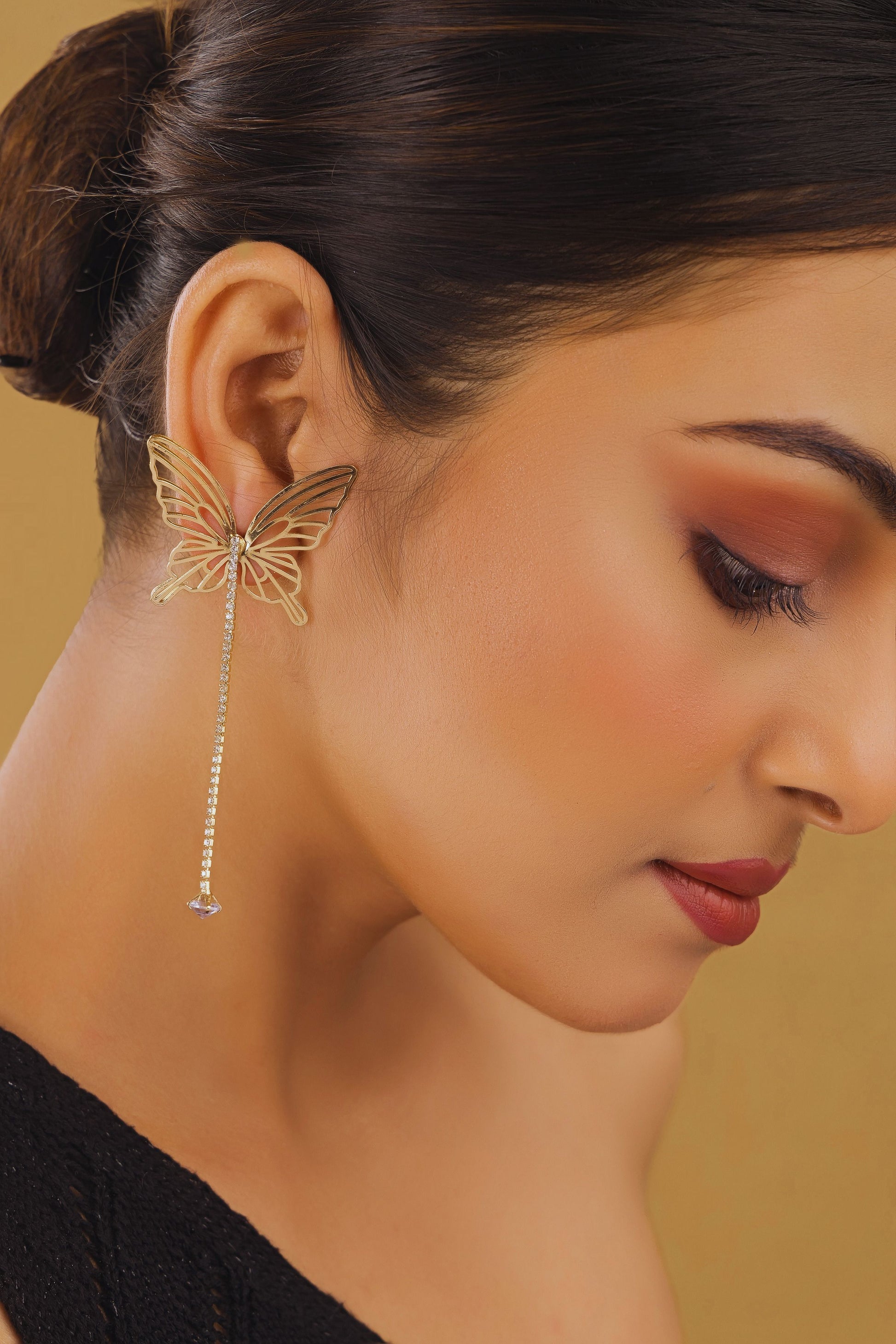 Close-up of a woman wearing a butterfly-shaped earring with a blurred background