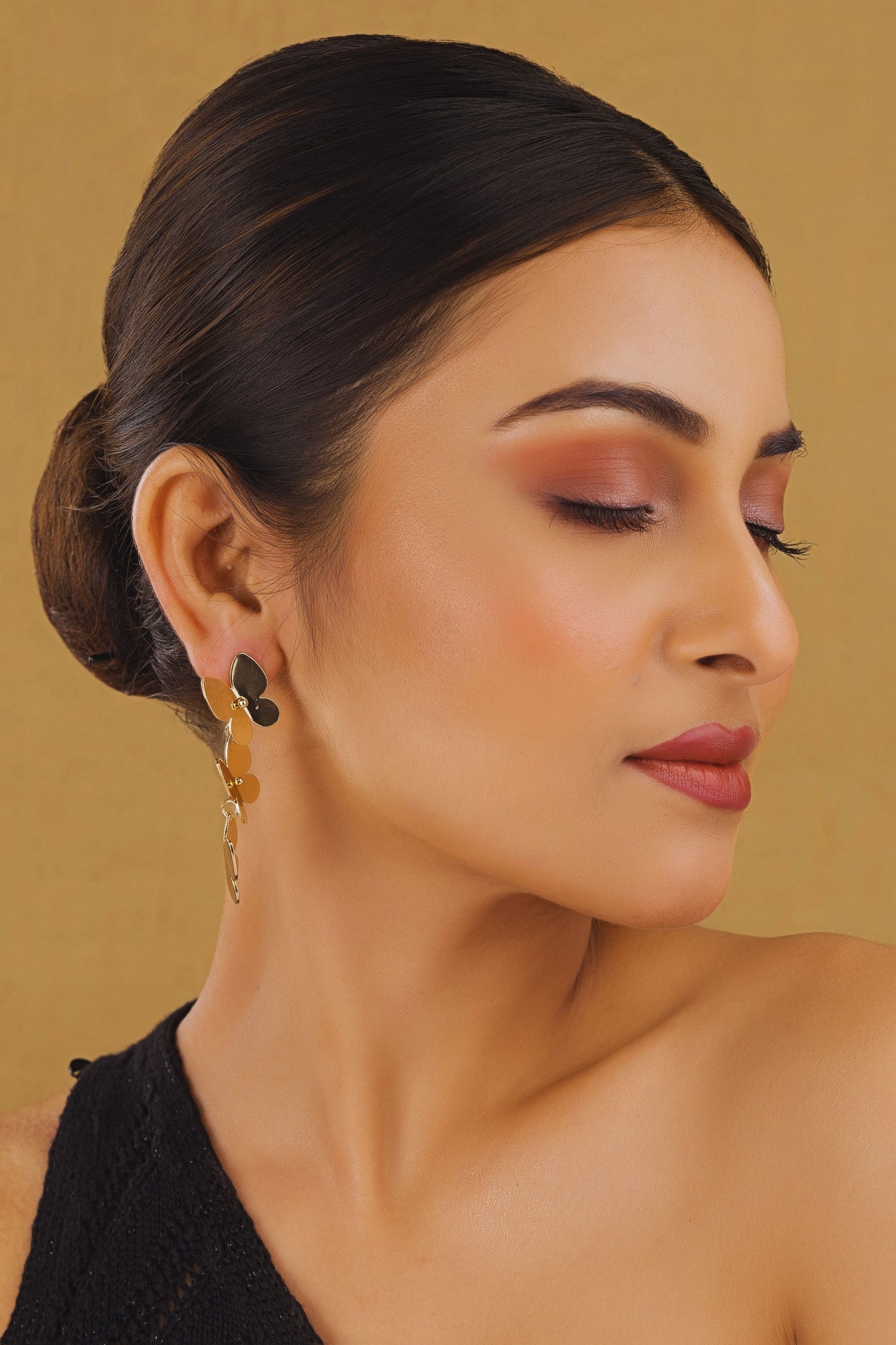 Woman with styled hair and makeup against a beige background