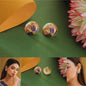 Pair of floral earrings on a green background with a woman wearing them.