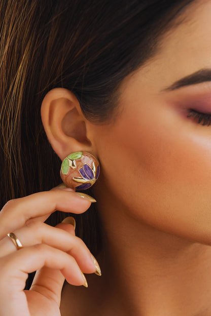 Close-up of a person wearing floral earrings with a blurred background