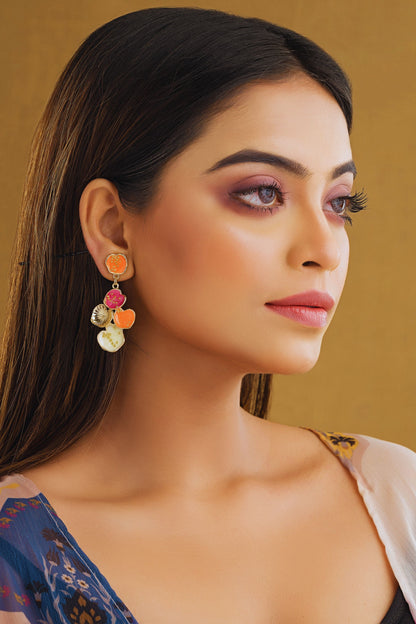 Woman wearing colorful earrings against a gold background