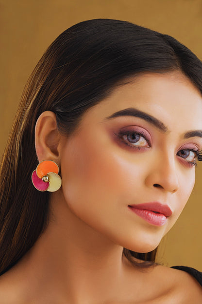 Close-up of a woman wearing colorful earrings with a neutral background