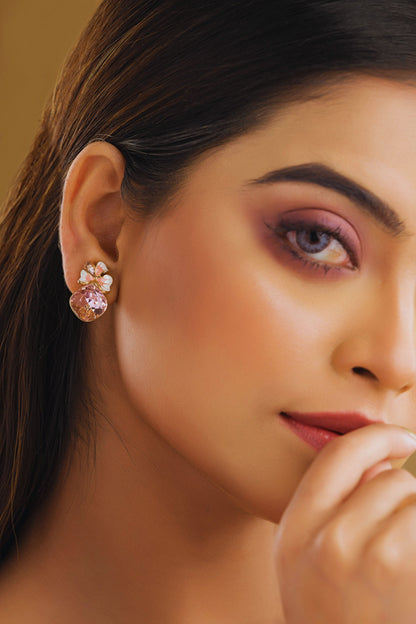 Close-up of a woman wearing a pink floral earring with a blurred background