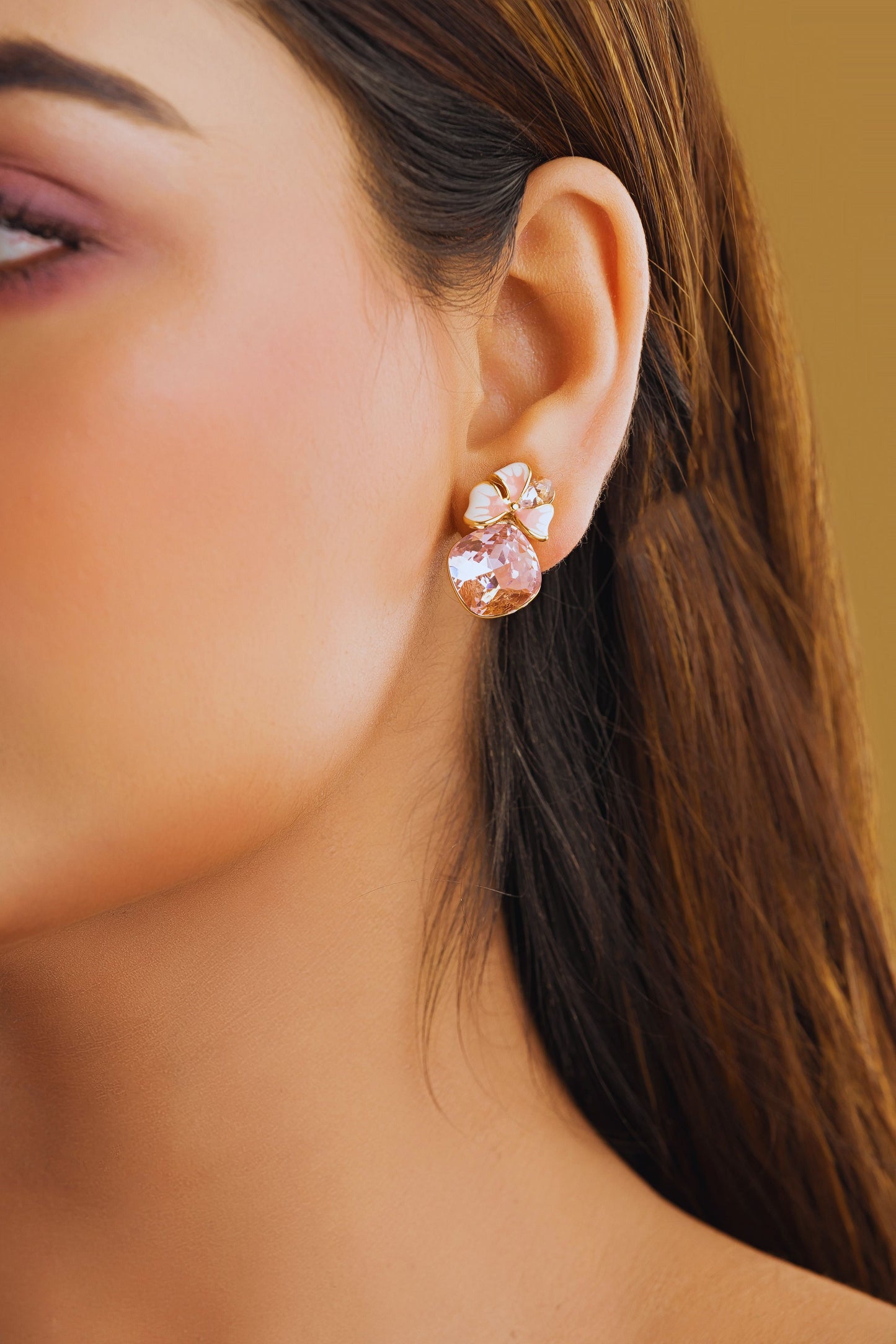 Close-up of a woman wearing a pink floral earring against a blurred background