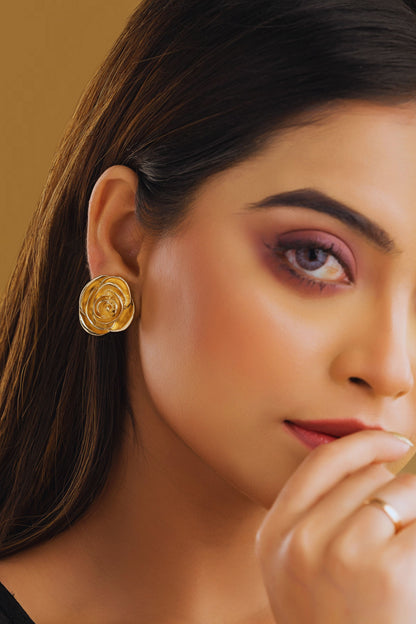 Close-up of a woman wearing gold earrings with a blurred background