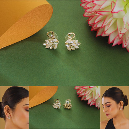 Gold earrings on a green background with a close-up of an ear wearing the earrings.
