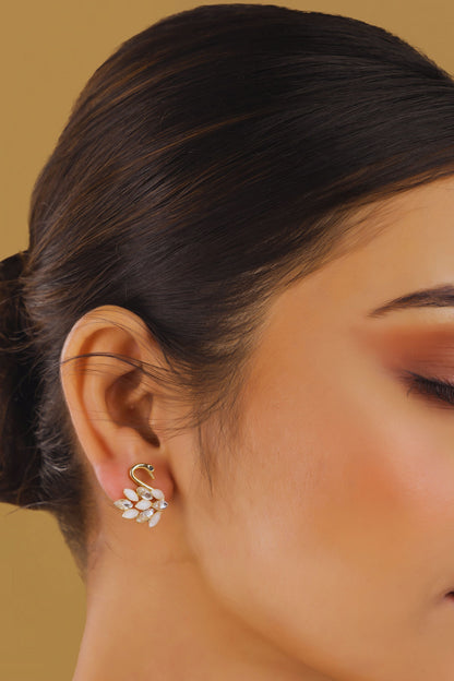 Close-up of a woman wearing a floral earring against a beige background