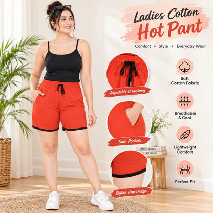 Cotton Hot Pants for Women. A woman modeling bright red cotton shorts with a black drawstring and black side trim, paired with a black camisole and white sneakers in a bright indoor setting. The image includes feature callouts and inset close-ups of the shorts, with text reading 'Ladies Cotton Hot Pant' and product benefits such as soft cotton fabric, breathable comfort, side pockets, adjustable drawstring, and stylish fit.