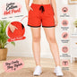 Cotton Hot Pants for Women. A woman modeling bright red drawstring shorts with black trim, shown from the waist down in a home setting. The image includes marketing text and feature icons for the shorts, such as soft cotton fabric, breathable and cool, lightweight comfort, durable and long lasting, and adjustable drawstring.
