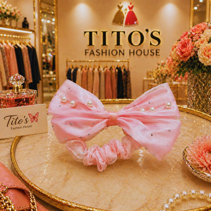 Pink bow headband with pearls on a decorative table in a fashion store setting.