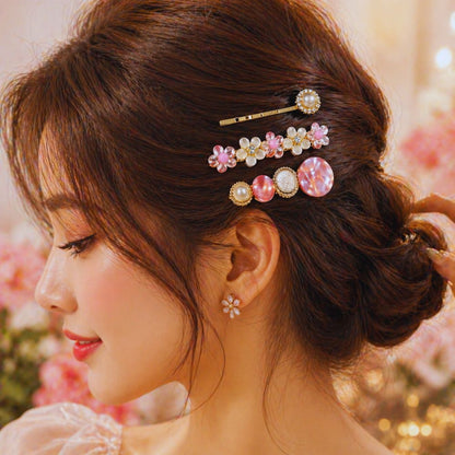 Woman with styled hair featuring decorative hairpins against a blurred floral background