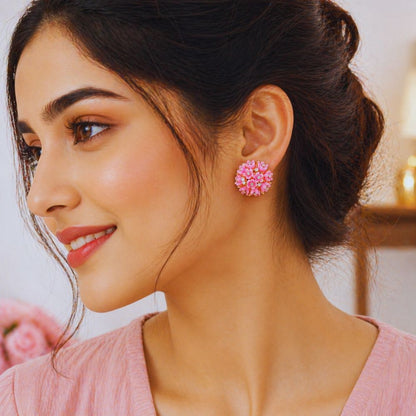 Woman wearing pink floral earrings with a blurred background
