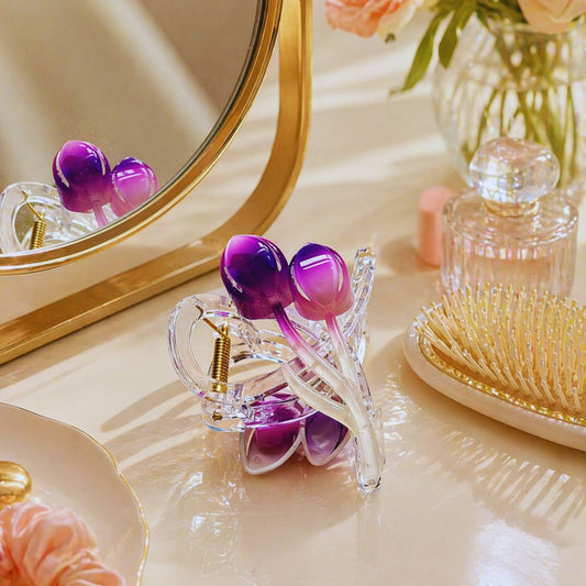 Purple hair clips on a vanity table with a mirror and hairbrush.