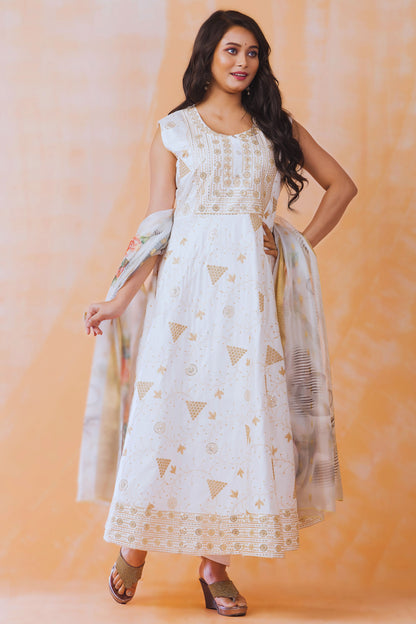 Woman wearing a white dress with gold patterns against an orange background