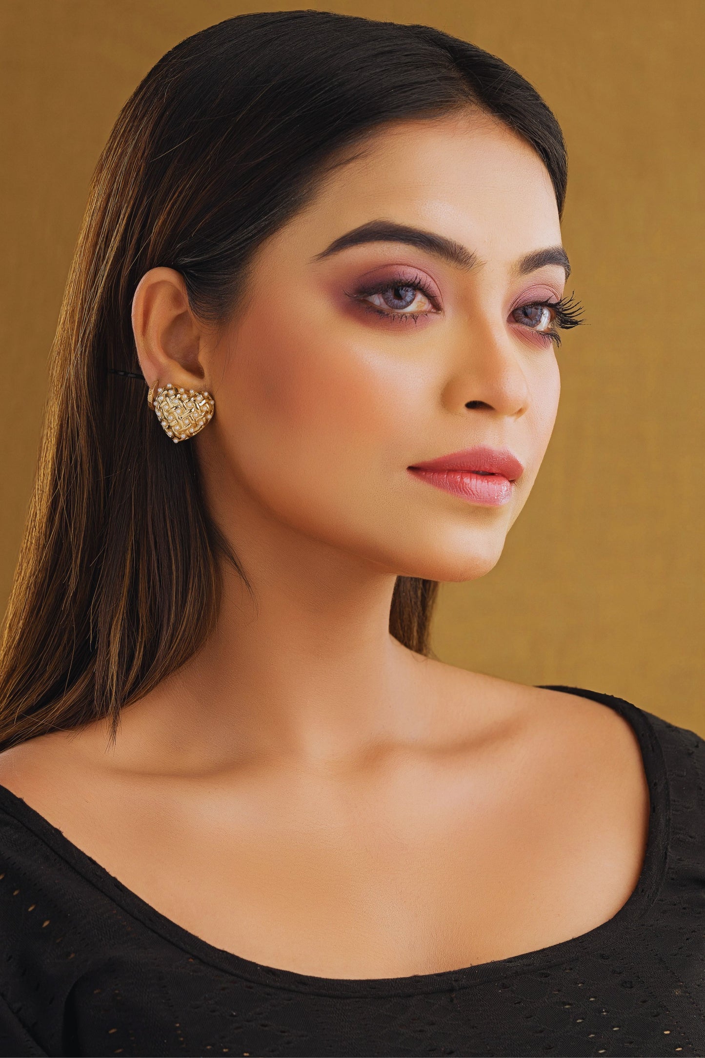 Woman wearing a black top with a gold background