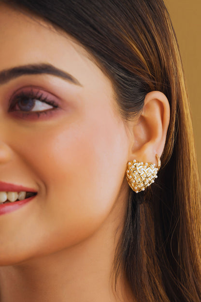 Close-up of a woman wearing a gold earring with a blurred background