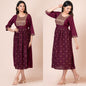 Woman wearing a maroon dress with gold embroidery on a beige background