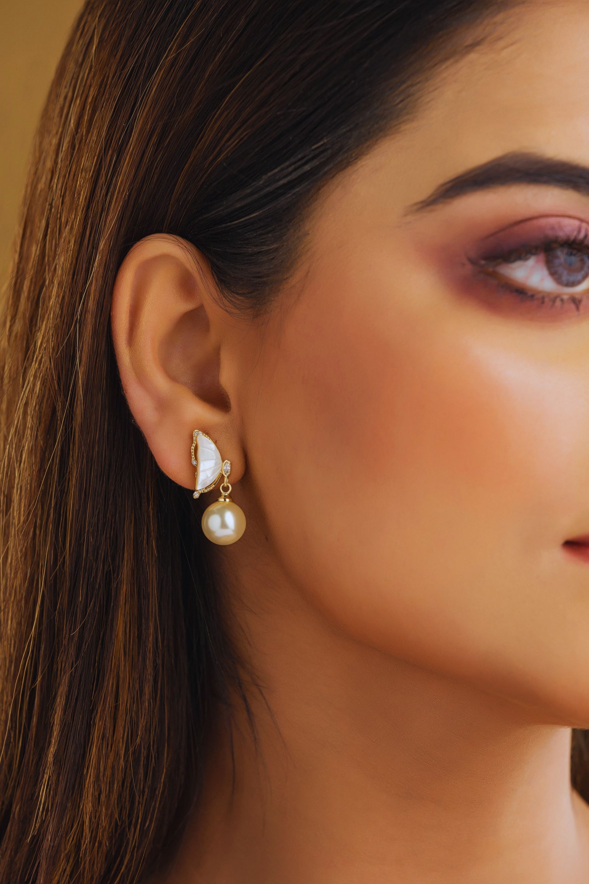 Close-up of a woman wearing a pearl earring with a blurred background
