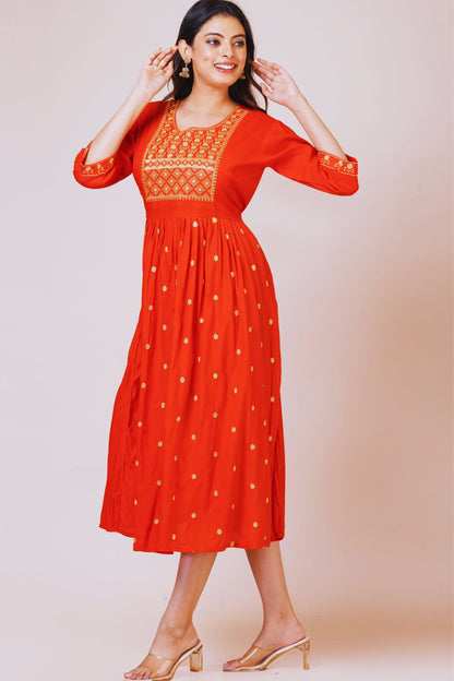 Woman wearing a red dress with gold embroidery on a beige background