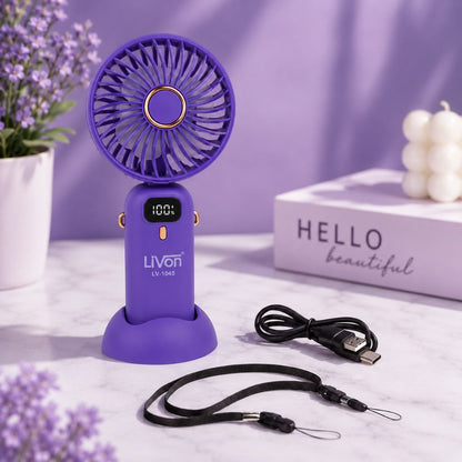 Purple handheld fan with USB cable on a light purple surface with decorative elements.