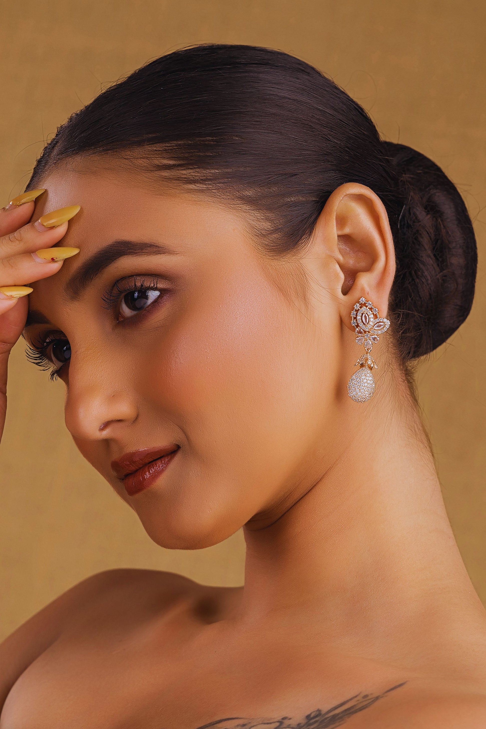 Woman with elegant earrings on a beige background