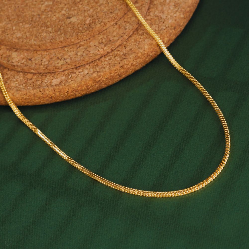 Gold chain on a green fabric background
