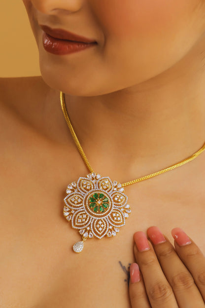 Close-up of a person wearing a gold necklace with a decorative pendant on a beige background