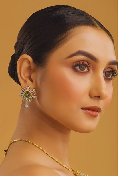 Woman wearing gold earrings with a yellow background