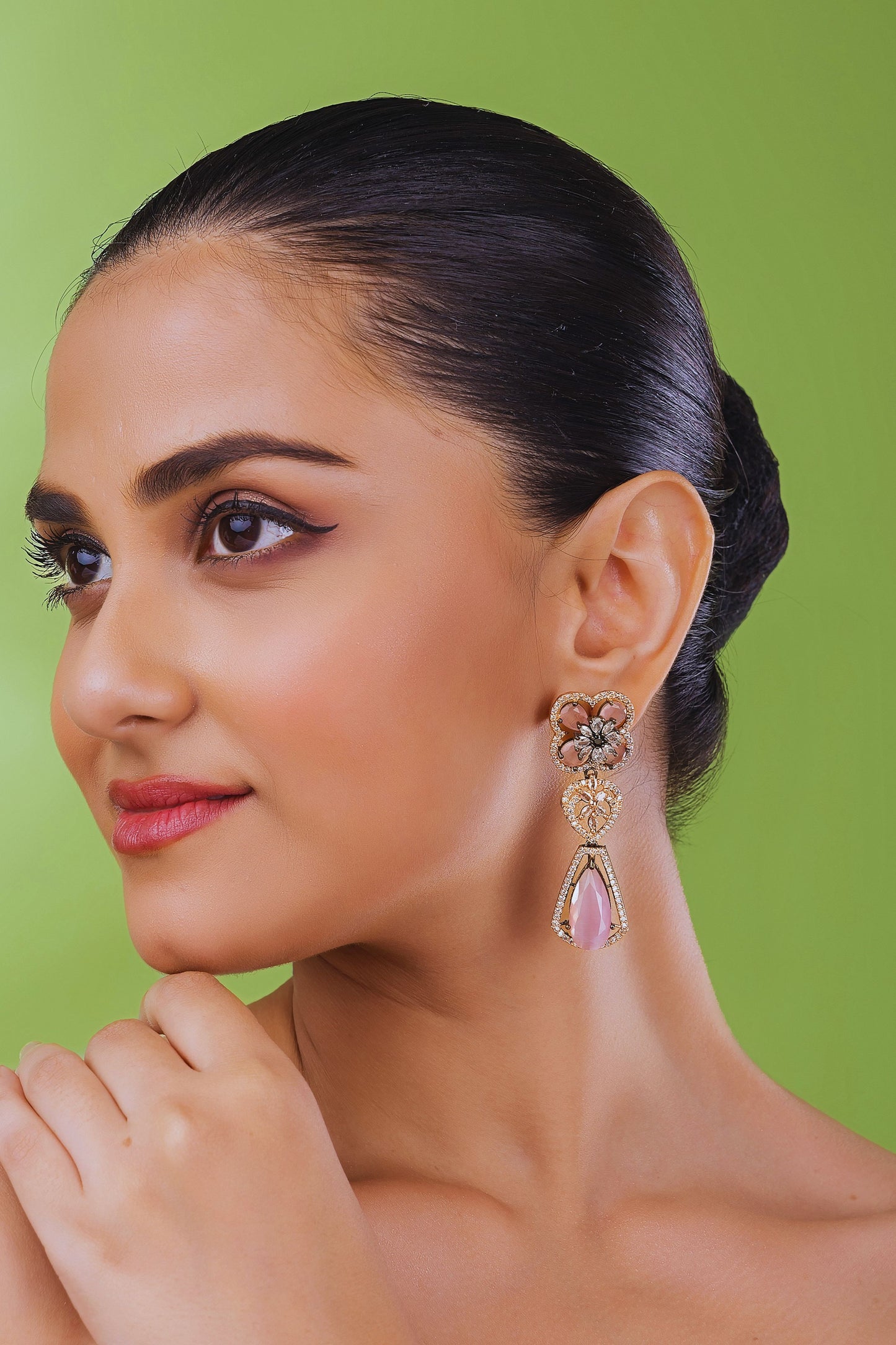Woman wearing a floral earring against a green background