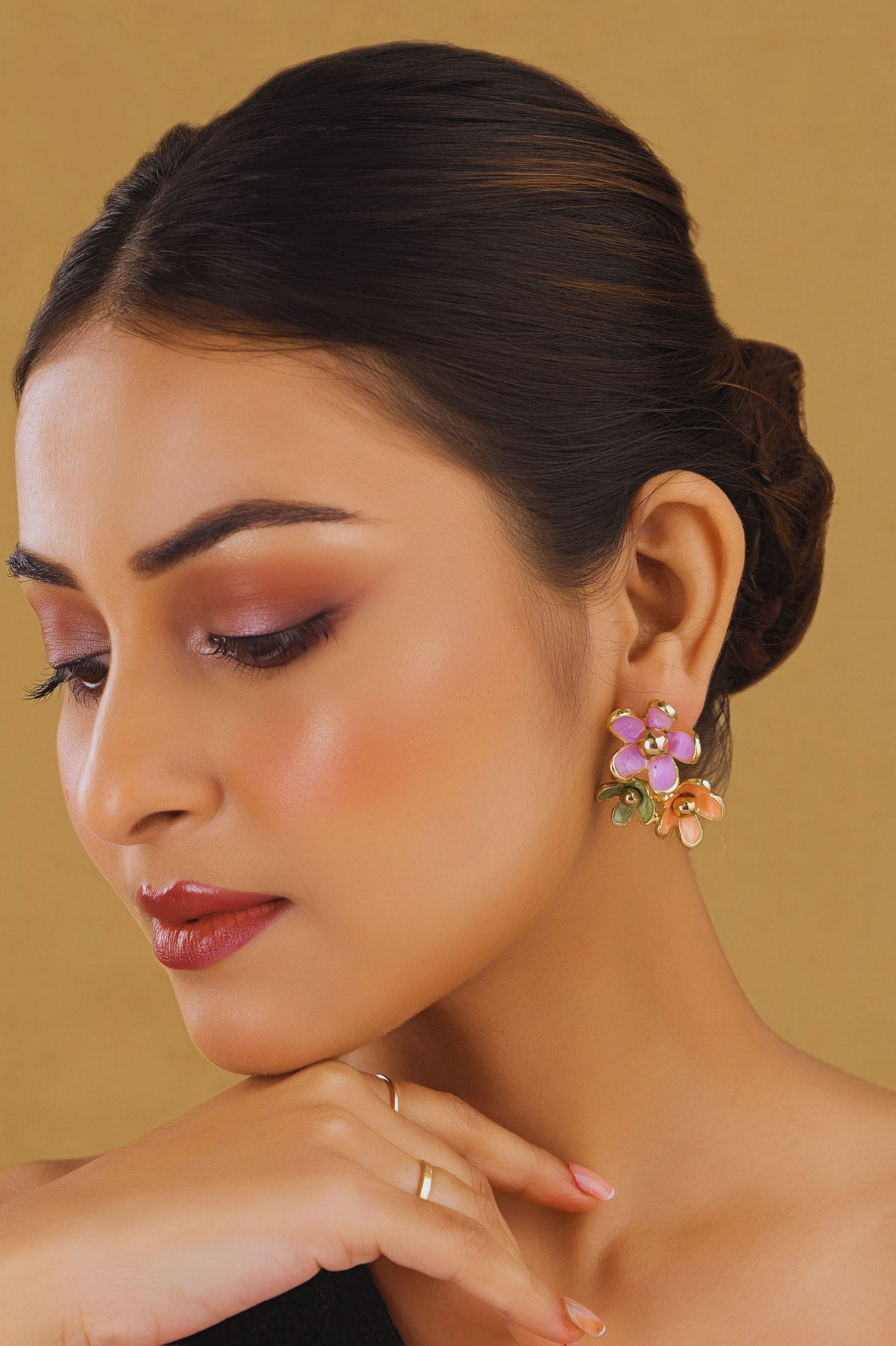 Woman wearing floral earrings against a beige background