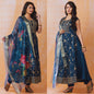 Woman wearing a blue embroidered outfit with a floral dupatta on an orange background