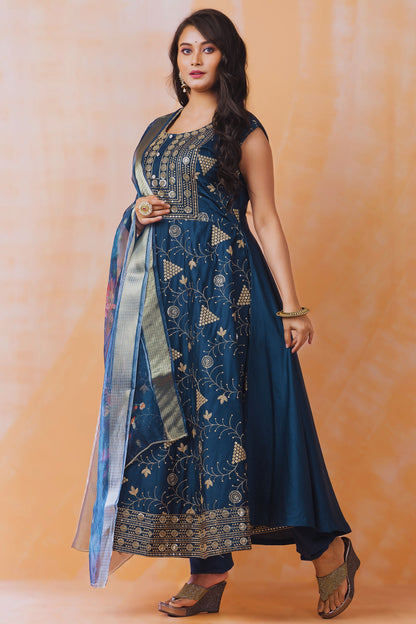 Woman wearing a blue embroidered traditional outfit on an orange background