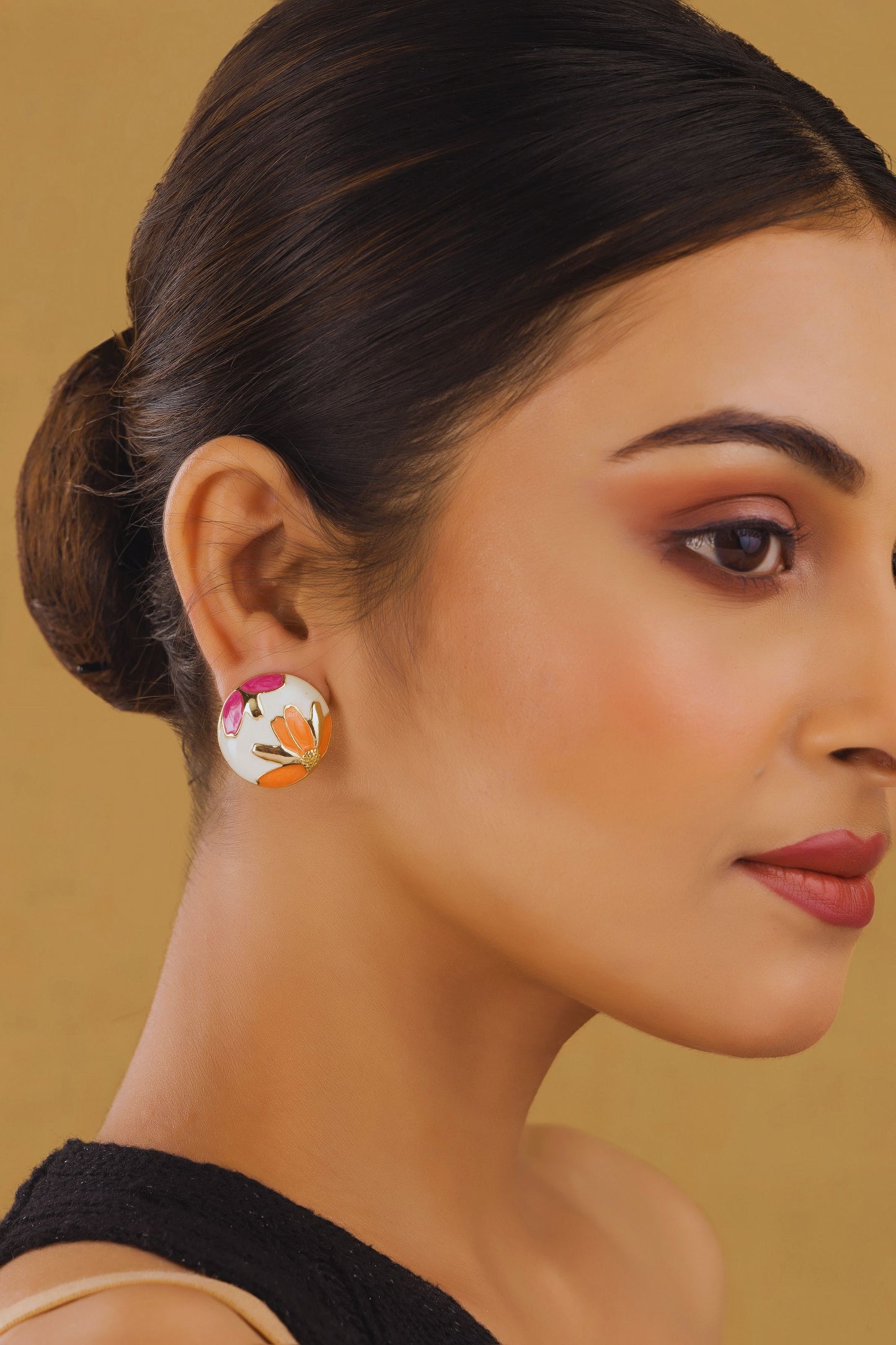 Woman wearing a floral earring against a beige background