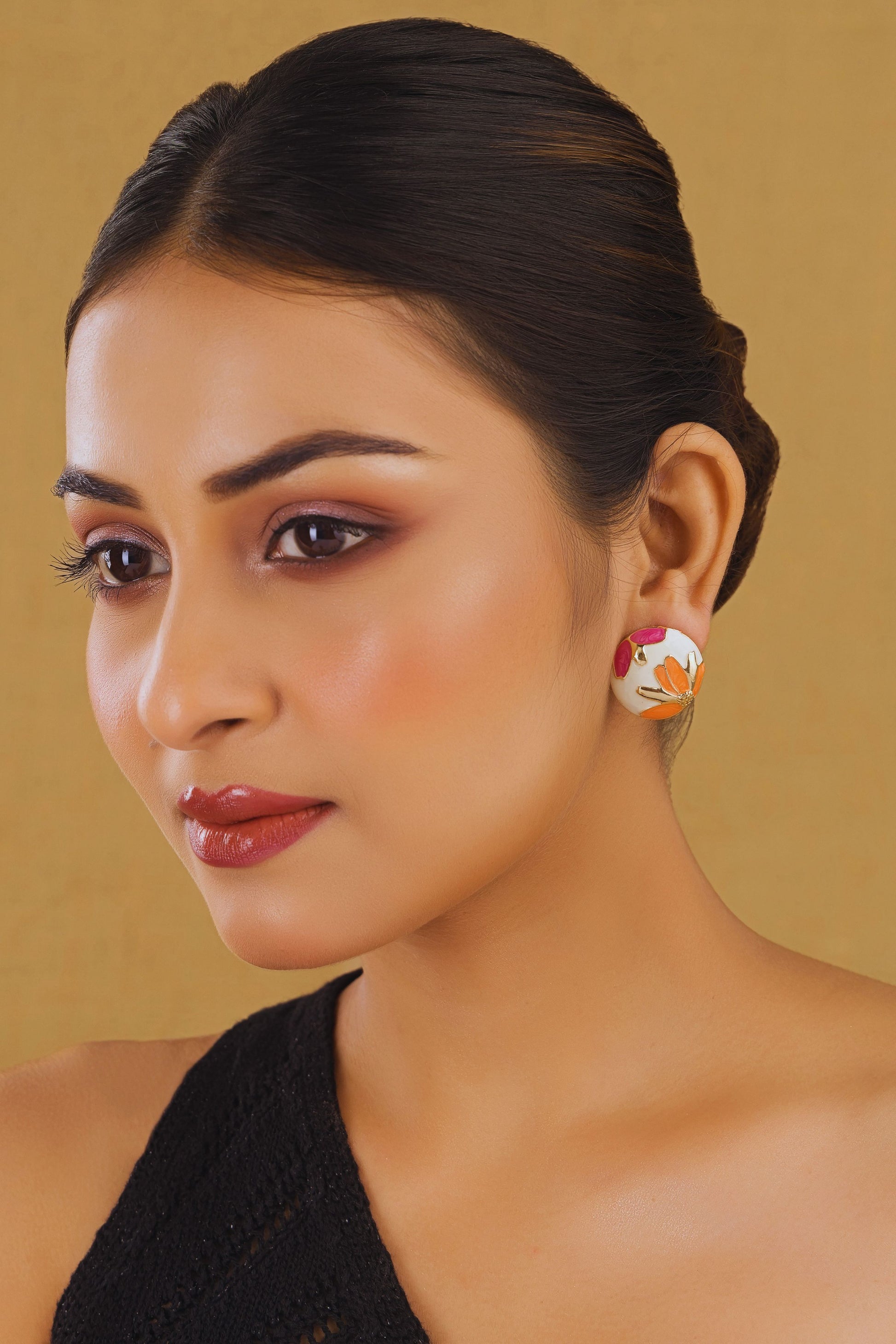 Woman wearing floral earrings against a beige background