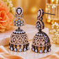 Ornate earrings with intricate designs on a soft fabric background