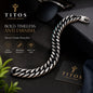 Silver chain bracelet on a dark surface with TITOS branding.