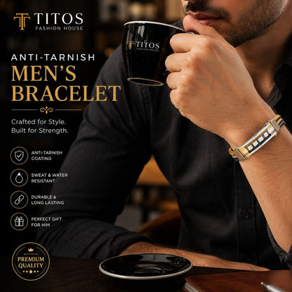 Man drinking from a black cup with 'TITOS' branding, wearing an anti-tarnish men's bracelet.
